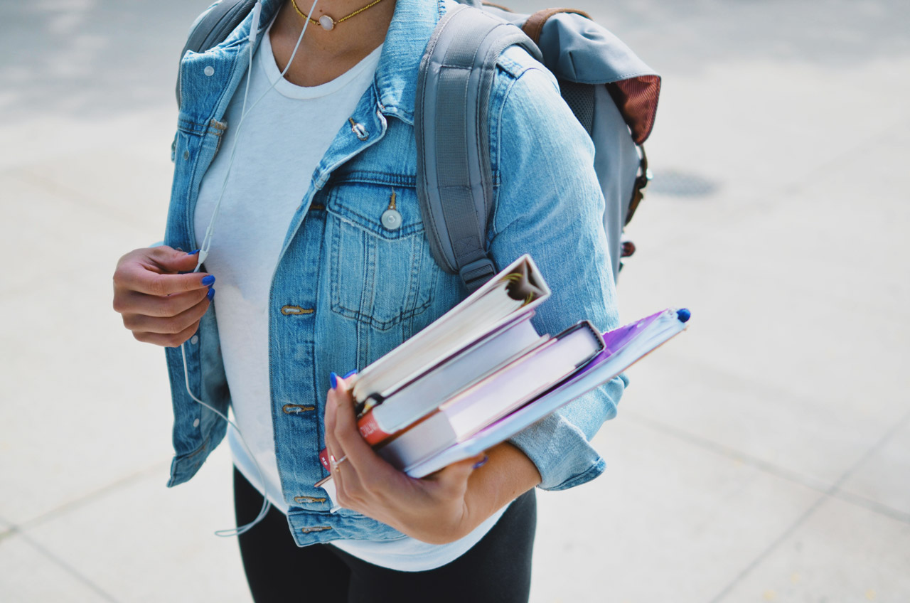 Etudiant portant ses livres de cours