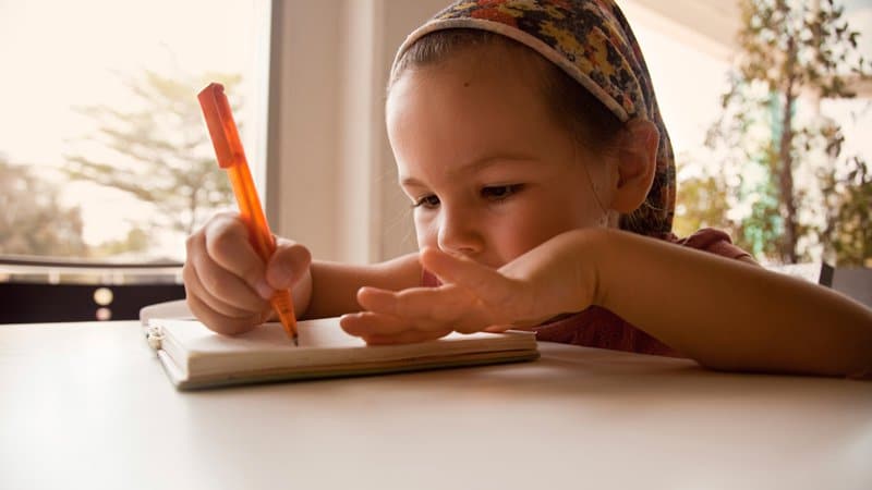 Petite fille en train de travailler sur un cahier