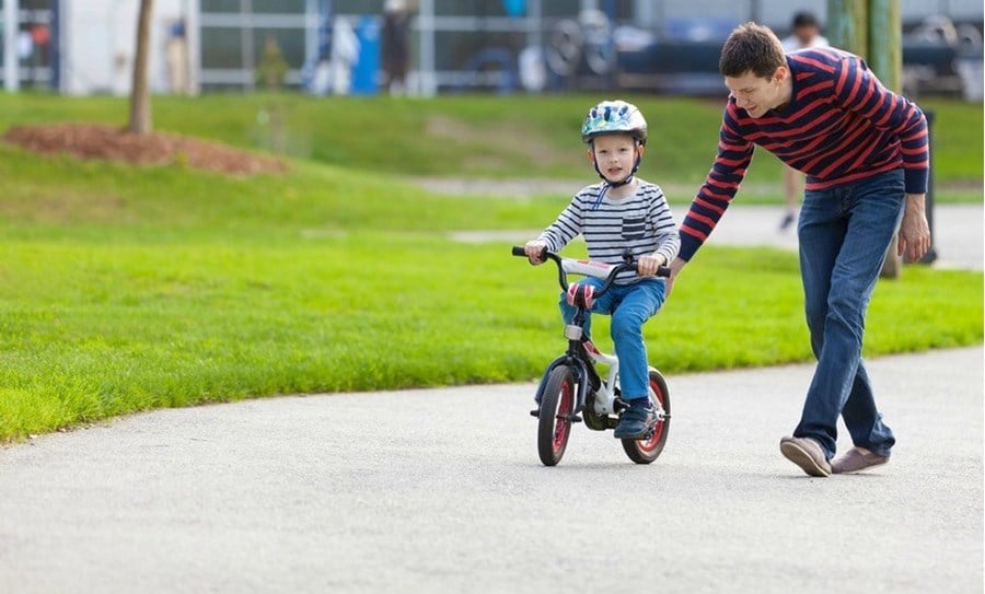Petit garçon apprenant à faire du vélo avec son père
